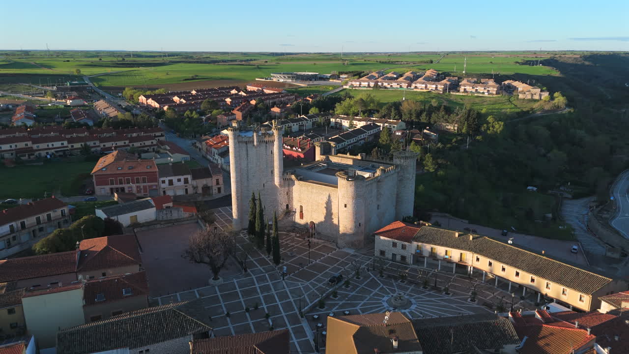 Drone orbit showcasing the historic Castle of Torija in Guadalajara, Spain. Captured during golden hour, the shot reveals architecture, rooftops, and rural surroundings from an elevated perspective
