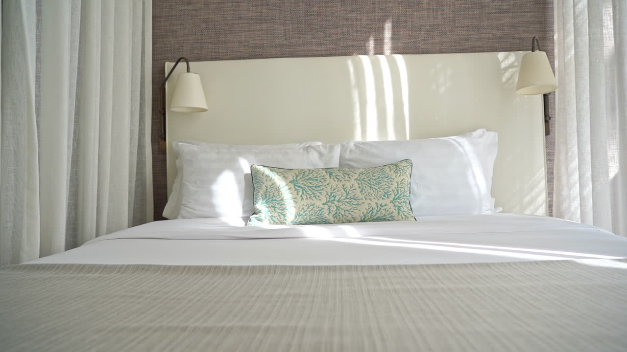 Slow pan right on made up bed in bungalo resort in Thailand