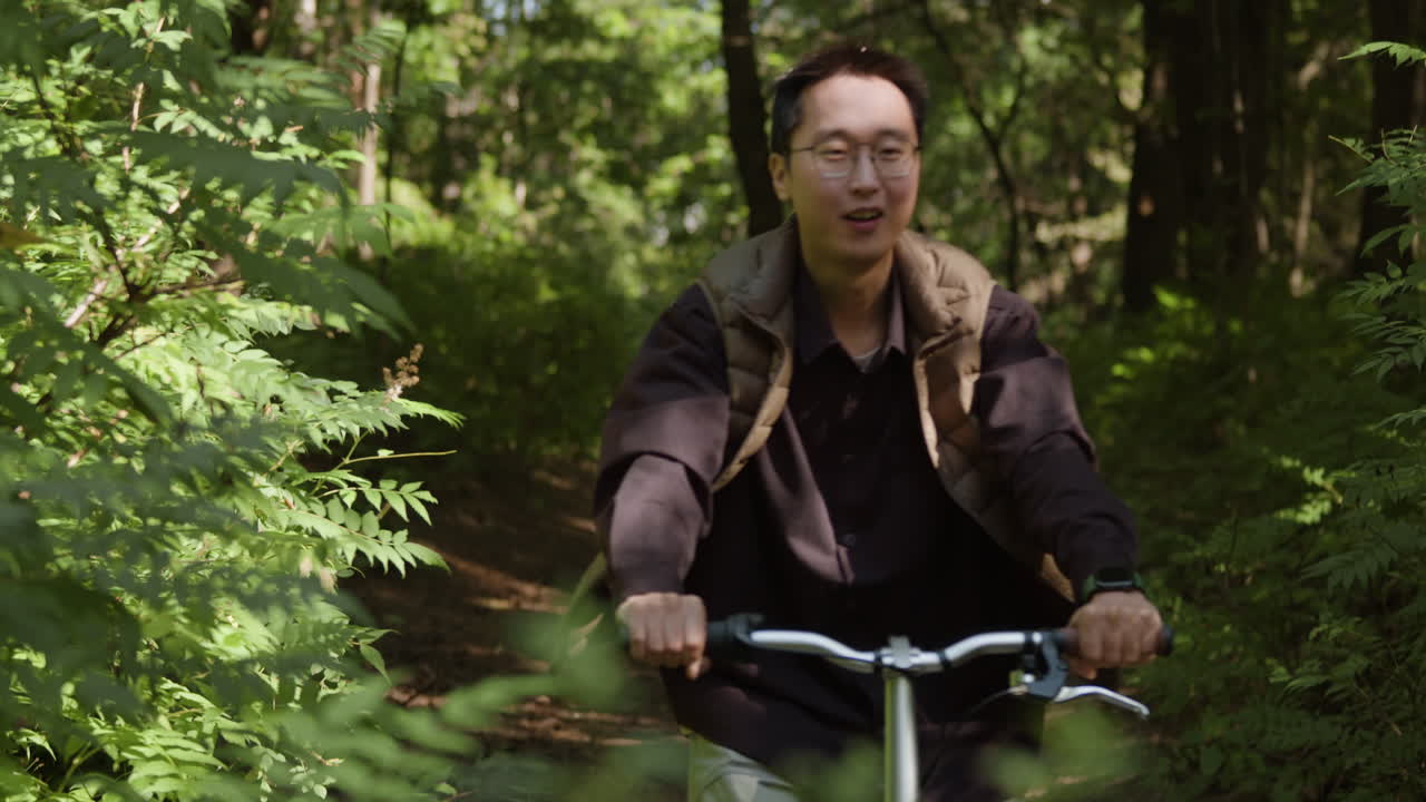 Man riding a bicycle through a forest