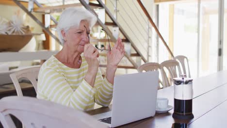 mujer caucásica mayor usando una computadora portátil en la sala de estar en casa