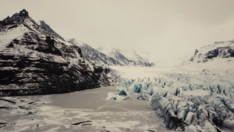 Lengua-Glaciar-En-Islandia-Filmada-Por-Drones-Con-Diferentes-Movimientos-Cinematográficos,-Mostrando-Un-Concepto-Turbio-Y-Dramático-En-Condiciones-Invernales