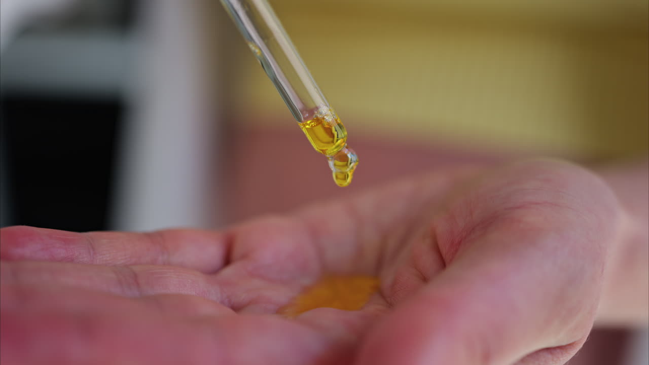 Close up of a pregnant woman poring oil in her hands