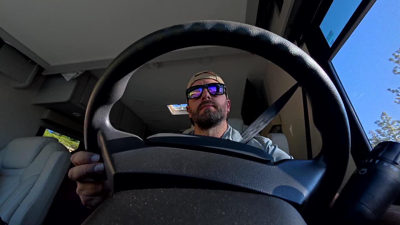 Man Driving a Recreational Vehicle on a Sunny Road Trip