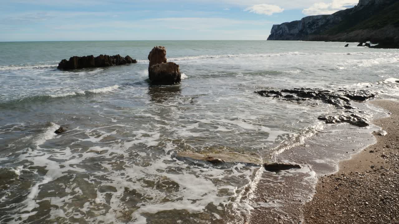 Rocce sparse tra la sabbia nella cala di Les Rotes, Denia, Spagna