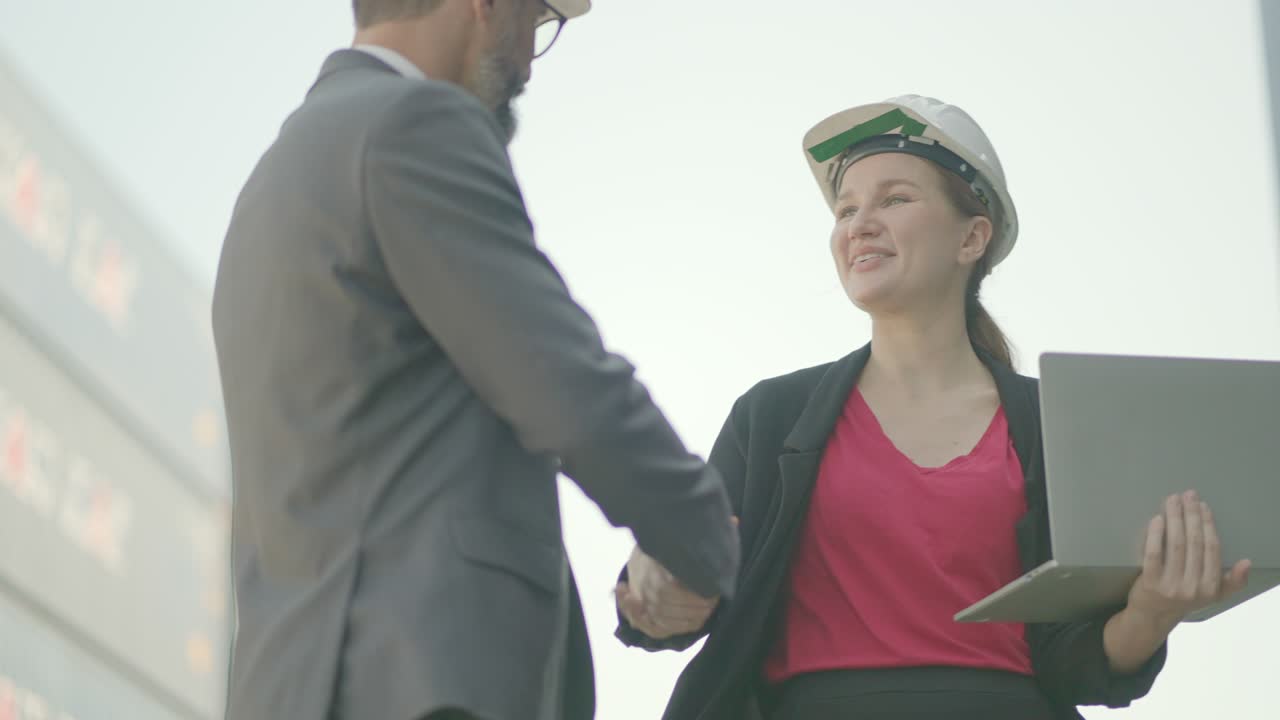 hombre ejecutivo o inversor y propietario de logística negocio o gerente mujer hablando y acuerdo plan de negocios de carga de transporte para hacer y apretar la mano felicitaciones por trabajar juntos. en patio de carga de contenedores.