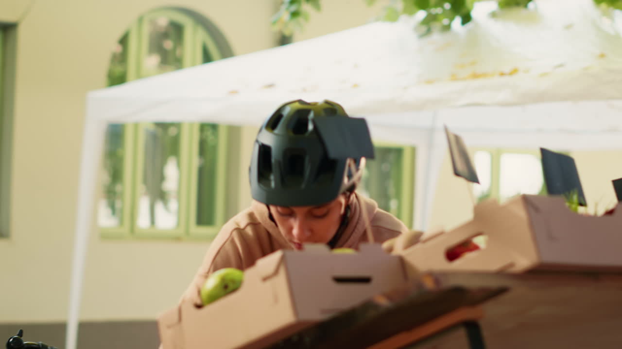 Woman on bicycle at market making food delivery