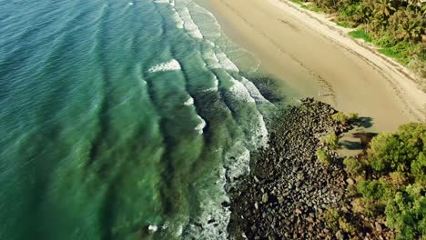 aerial view of waves crashing into the beach and protection net