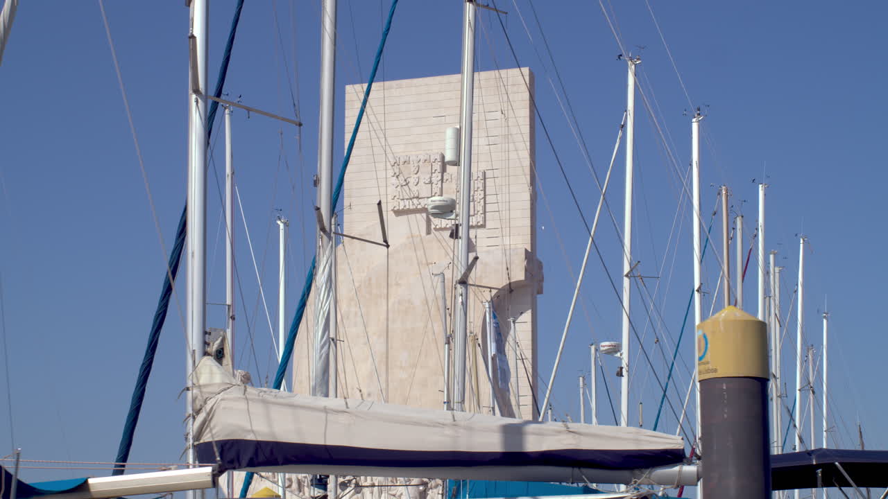 Padrão dos descobrimentos monument tracking shot by boat. Sailboat masts on shot.