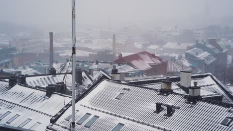 poste alto con cables moviéndose en el viento por encima del techo cubierto de nieve en st.