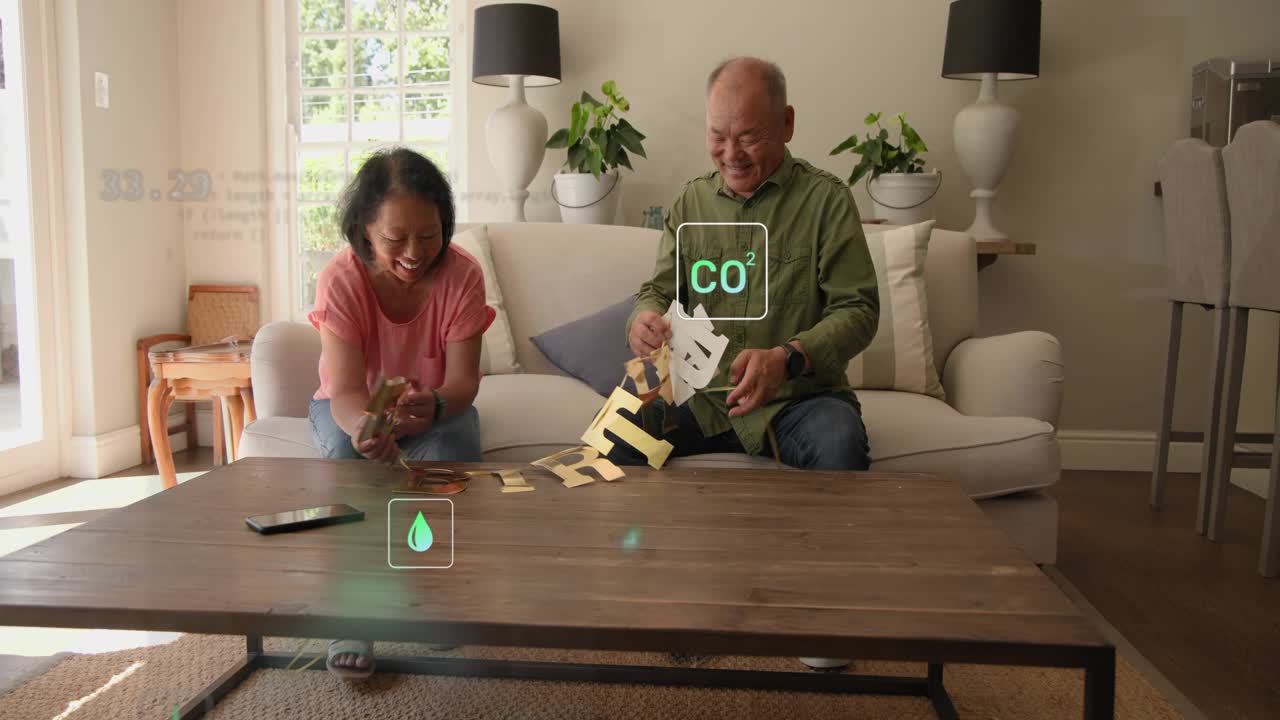 Woman reaching pieces and man linking garland on sofa assembling decor while tech icons appearing