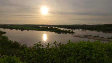 sunset reflected at polish natural reservoir lake in wilkow bay water landscape around greenery, delta river