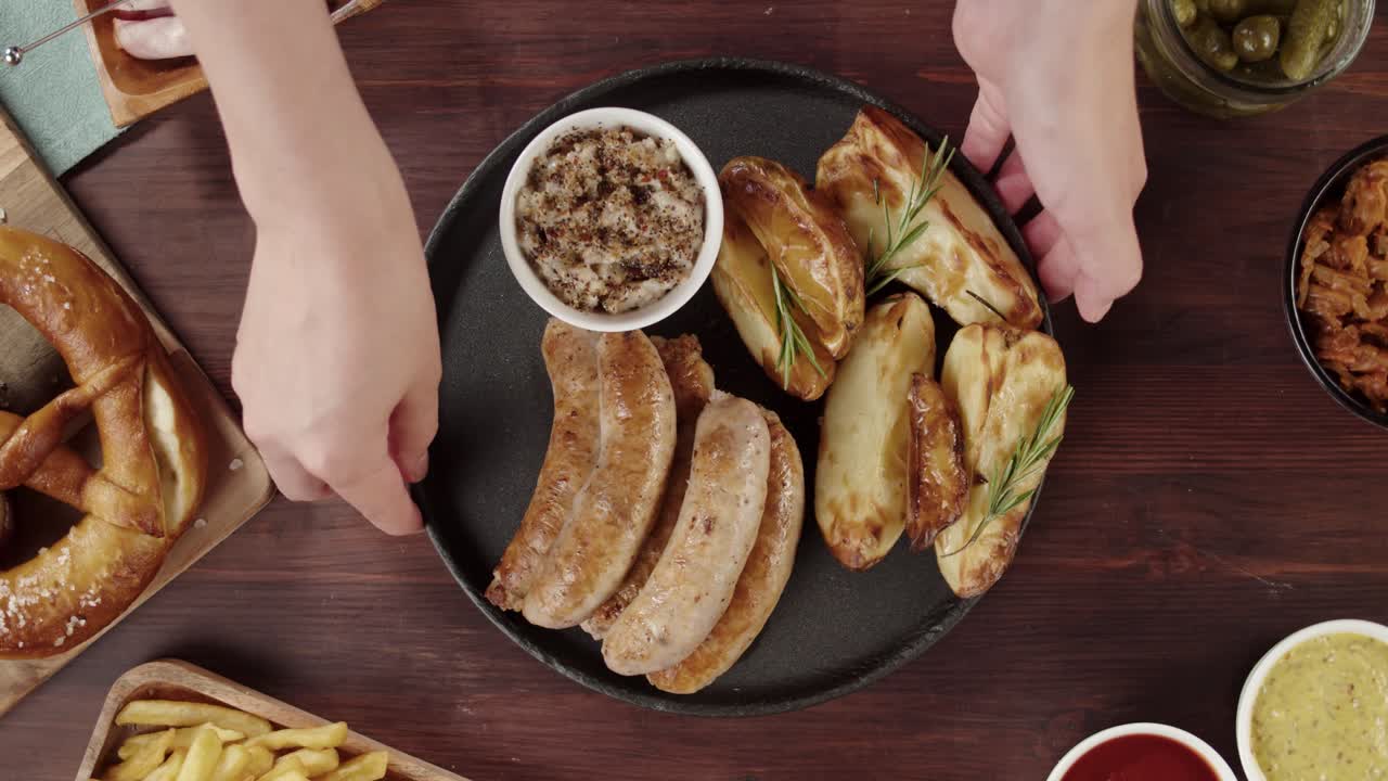 Servire un piatto di salsicce e patate a spicchi con senape