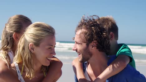 Eltern-Geben-Ihren-Kindern-Huckepackfahrt-Am-Strand