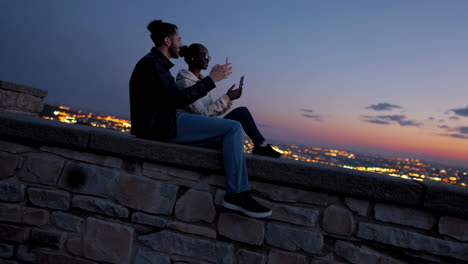 people capturing a scenic city view at dusk