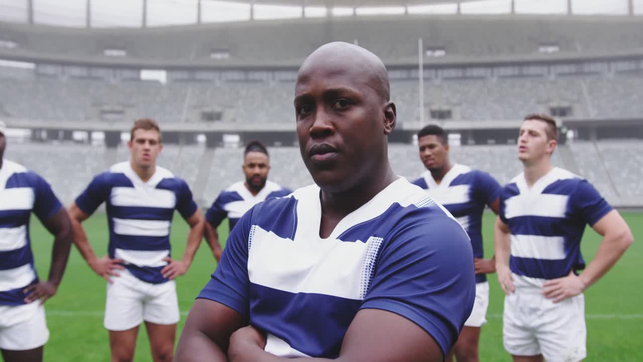 Manlig rugbyspelare står med armarna i kors på stadion 4k