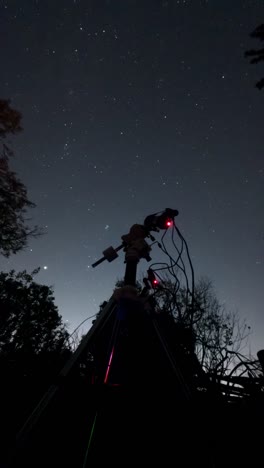 telescope and camera on a star tracker photographing deep sky objects in the night, vertical timelapse.