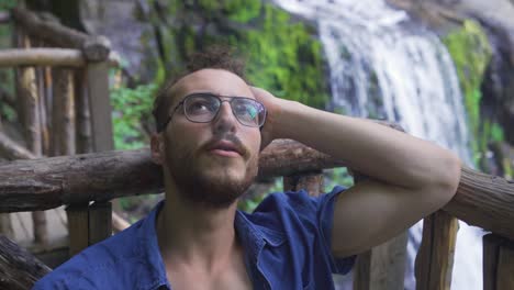 un joven adulto fumando en el bosque.