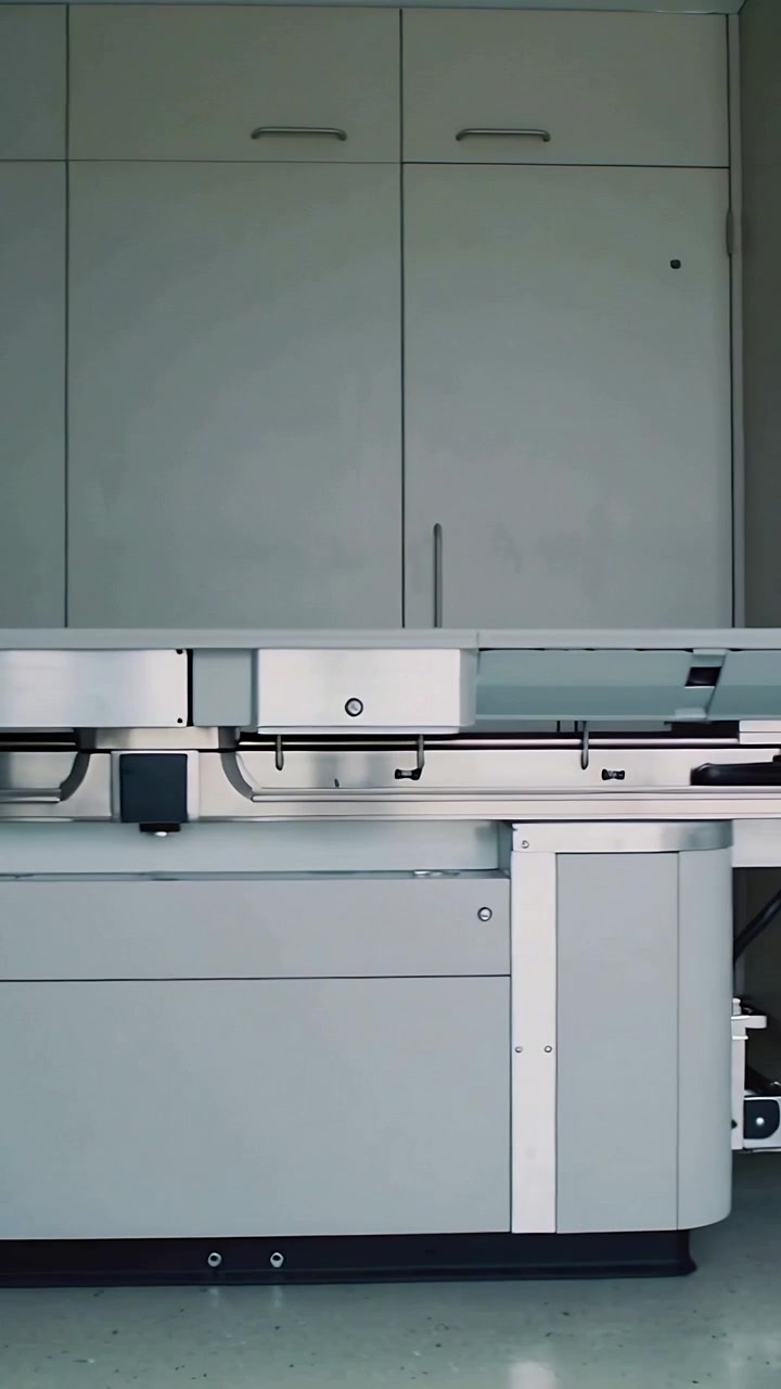 Vertical video: Panning camera revealing exam table in clinic showing rails, knobs