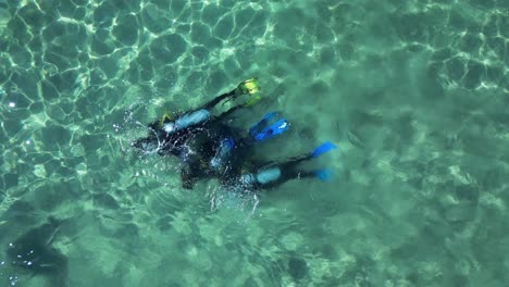 a scuba instructor teaching students how to use scuba equipment and dive gear underwater