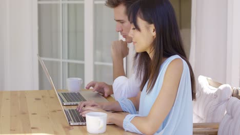 Couple-working-on-laptop-computers-together