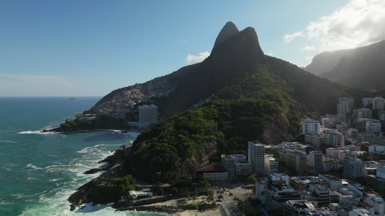 Un drone sale verso la costa di Leblon, rivelando le case collinari di Vidigal e le montagne Dois Irmãos sopra Rio de Janeiro