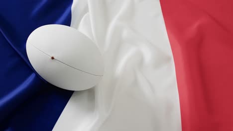 white rugby ball over flag of france with copy space, in slow motion