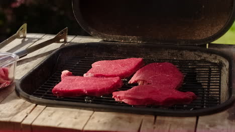 fresh beef meat cooking on the bbq or barbecue grill in sweden on a warm summer day