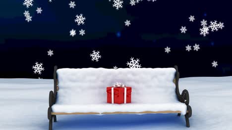 Animation-of-christmas-present-on-bench-with-snow-over-snow-falling-on-dark-background