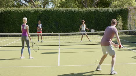 Fröhliche,-Vielfältige-Gruppe-Von-Freunden,-Die-Auf-Dem-Tennisplatz-Tennis-Spielen