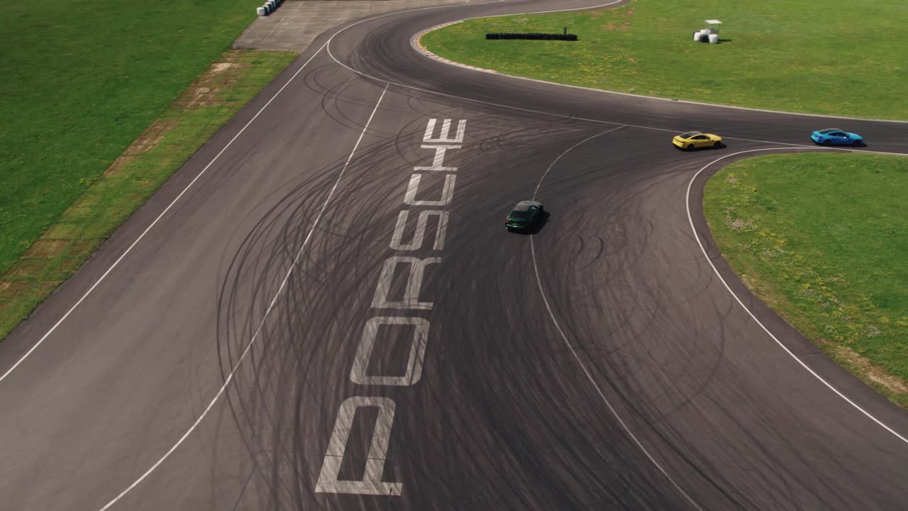4k Drone Shot of Sport Cars on a Race Track with Tire Marks on Asphalt, Sunny Day