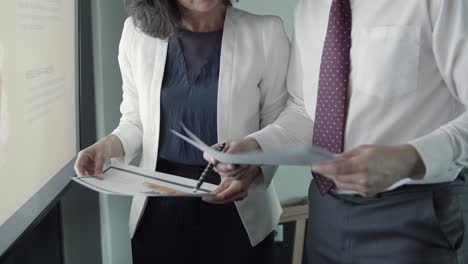 cropped view of business people holding papers with report