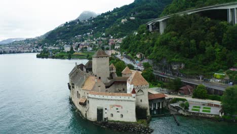 la cámara del avión no tripulado viene de detrás del castillo es un lugar turístico vista cinematográfica en el castillo de chillon en suiza