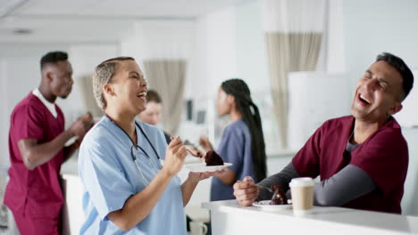 Happy-diverse-doctors-eating-birthday-cake-at-reception-desk-in-hospital,-slow-motion