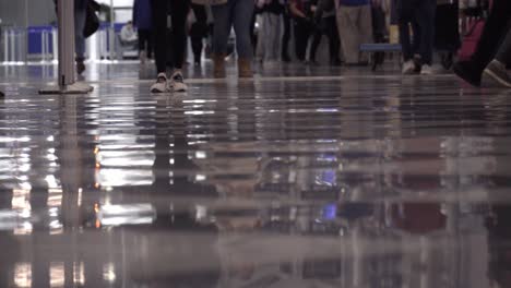 low angle view of legs in crowds walking down a terminal in o'hare international airport in chicago on dec 26th, one of the busiest days