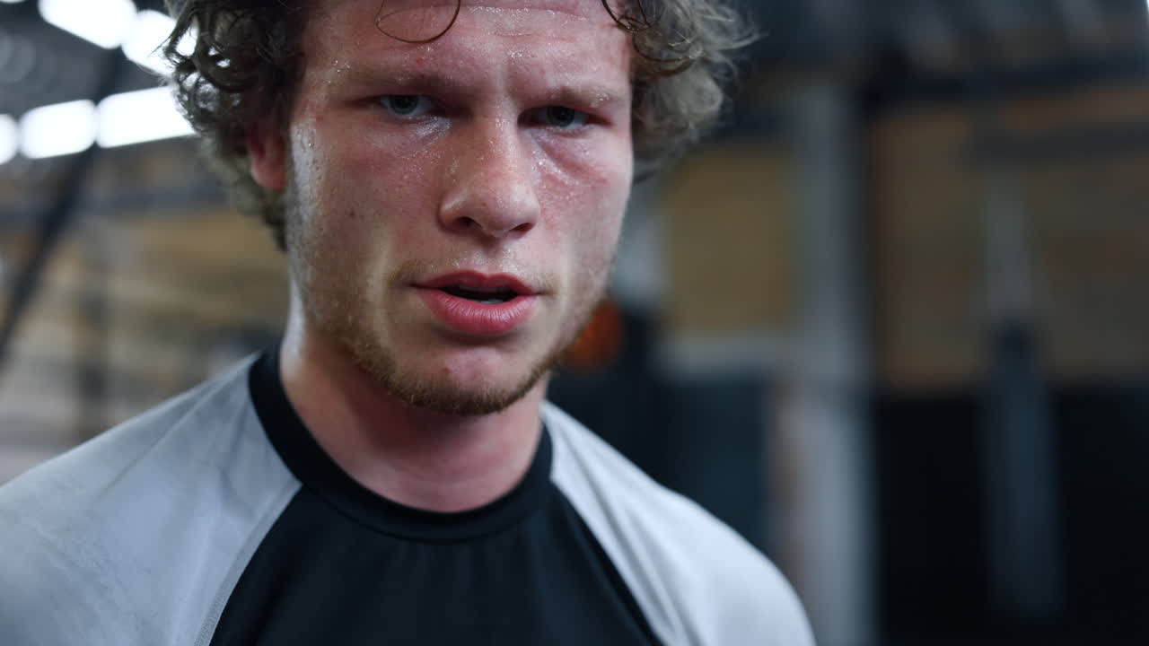 молодой кикбоксер отдыхает в спортзале. боец стоит в фитнес-центре