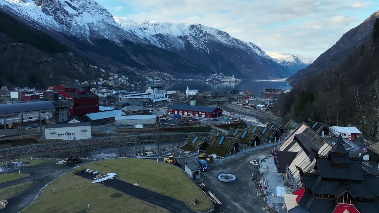 Aerial over Lothepus Camping in Odda Norway. Main building, stave church, and cabins with fjord view.