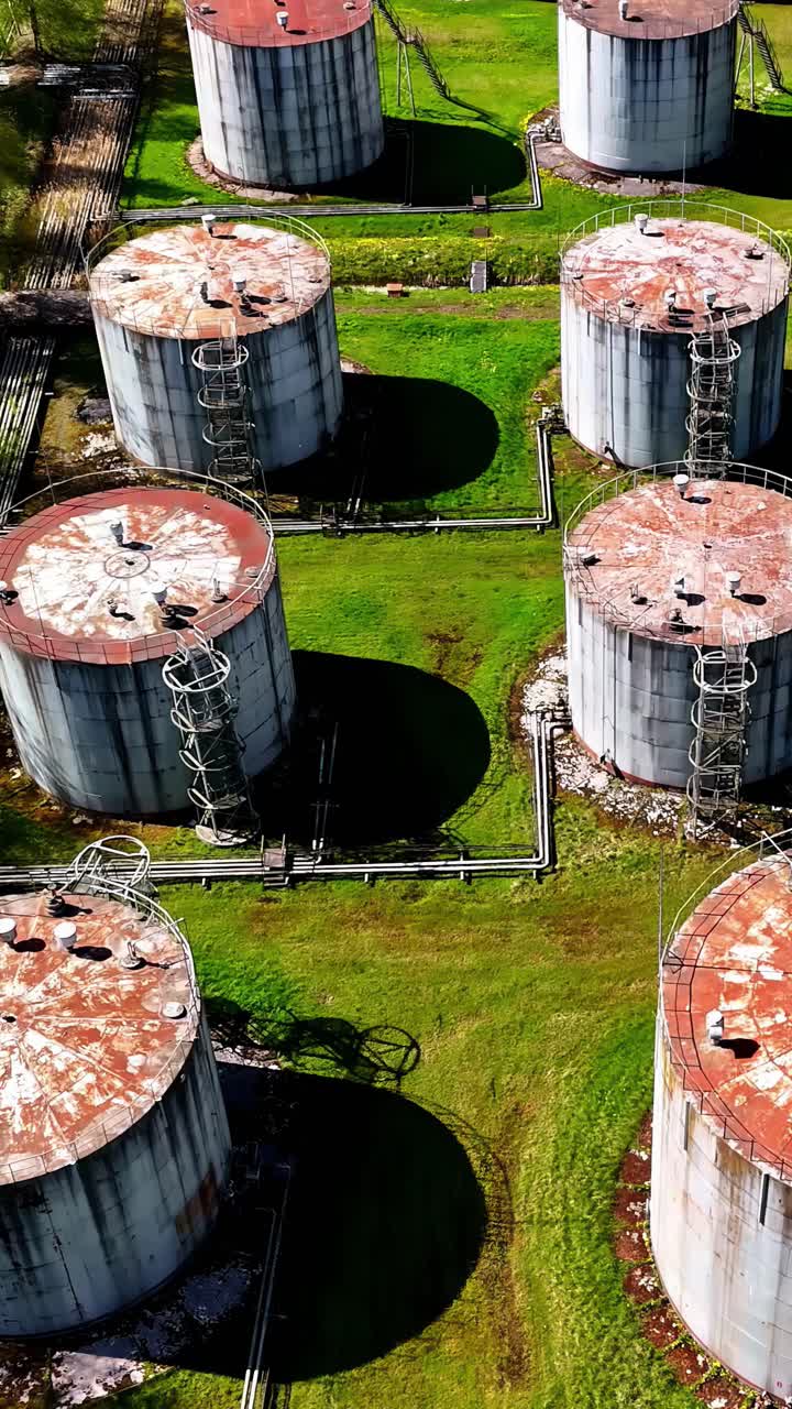 Rusty fuel silos in industrial area, aerial vertical view