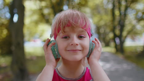 deportista, corredora, niña con auriculares escuchando su canción favorita en el parque.