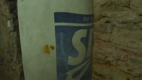 boxing punching bag hangs suspended with surface marked by stains of blood