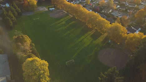 aerial footage of a beautiful soccer field in a friendly neighborhood in portland, oregon - city park for sport and fitness while sunset