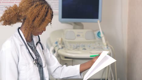 enfermeira afro-americana com um caderno em um hospital moderno. conceito de medicina, cuidados de saúde e pessoas