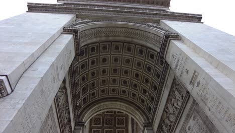 looking up into the arc de triomphe monument in paris, france