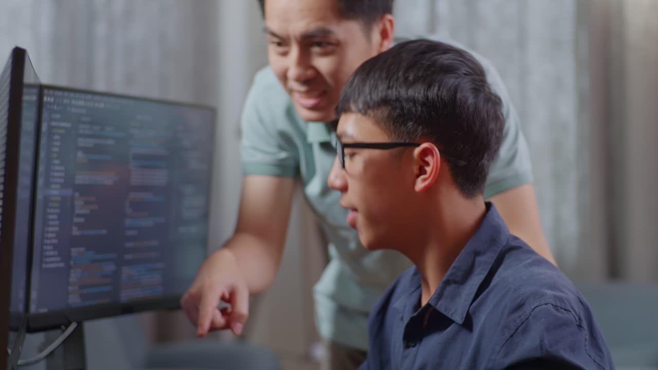 Two Asian men collaborating on a coding project