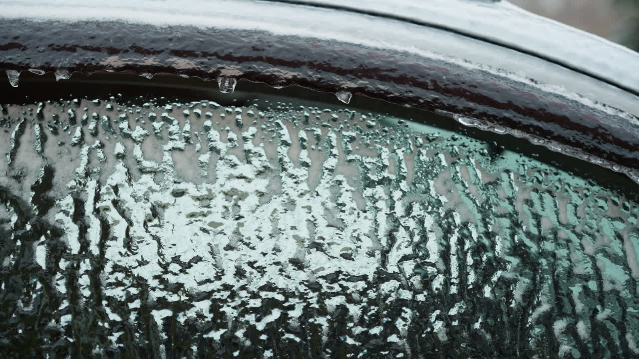 차에서 얼음의 복잡한 패턴과 녹는 물방울을 보여주는 차가운 겨울 날의 날카로운 세부 사항과 질감을 강조하는 차가운 유리 유리의 상세한 클로즈업