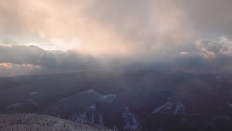 Smrk-peak,-Camera-pan-down-and-and-preparing-to-land-above-frozen-trees-towards-the-clouds-in-Beskydy-mountains,-UHD-or-4k,-30fps