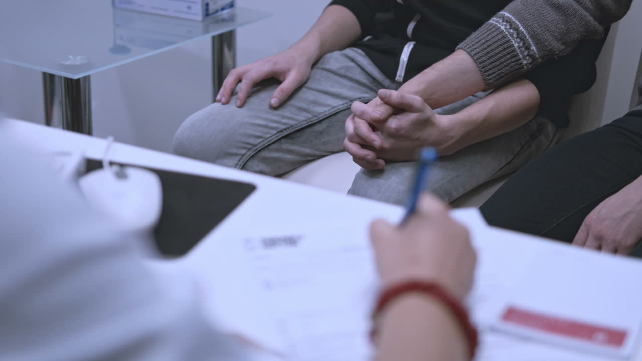 Læge noterer behandling. Homoseksuelt par venter på hiv-testresultater.