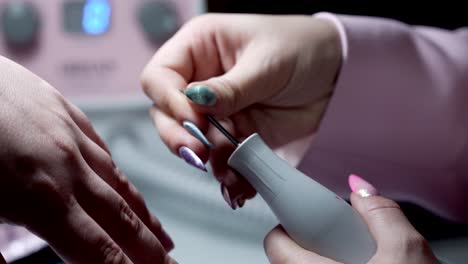 close up of hands loading drill bit into electric nail file