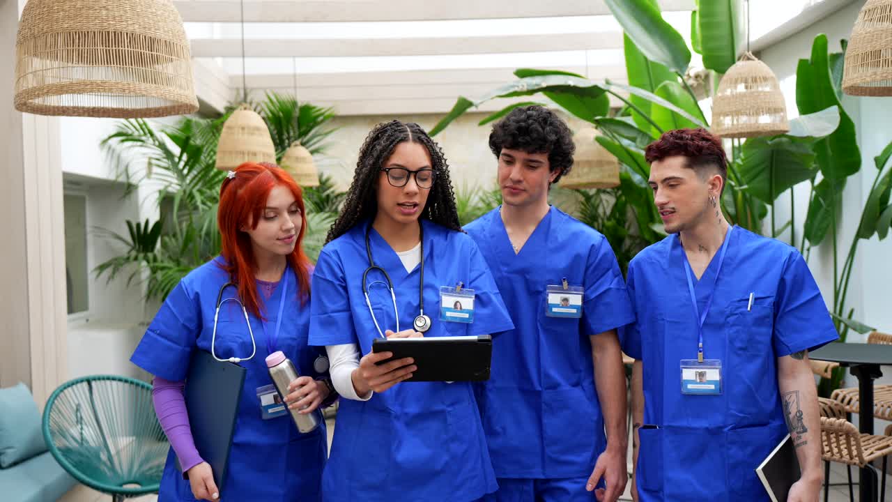 Profesional Medis Muda Mendiskusikan Informasi di Tablet.