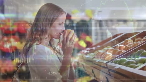 Animation-of-data-processing-over-smiling-caucasian-woman-smelling-fruit-in-shop