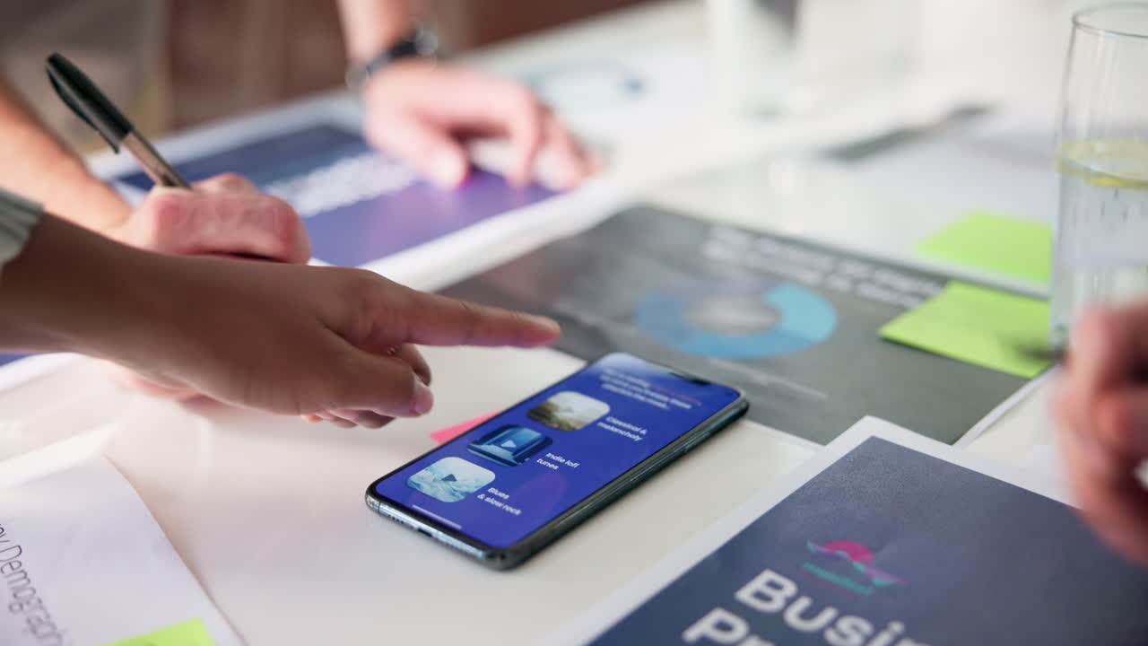 Team collaborating on business plan using smartphone